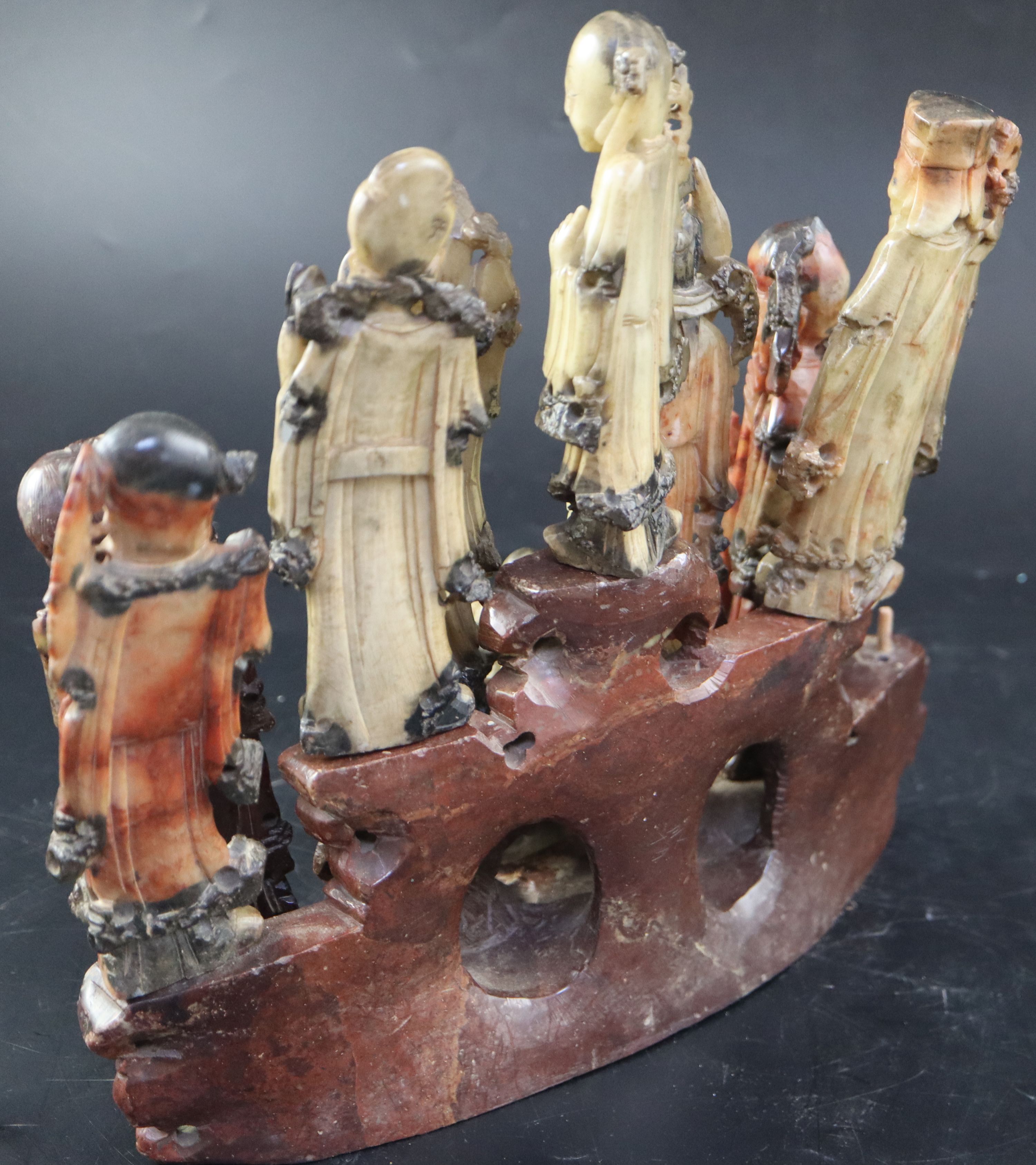 A group of nine Chinese Taoist carved coloured soapstone figures of immortals, width 29cm height 27cm